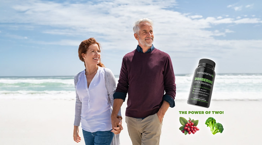 Happy mature couple walking on beach with DIMBERINE supplement bottle showing berberine and DIM for healthy aging